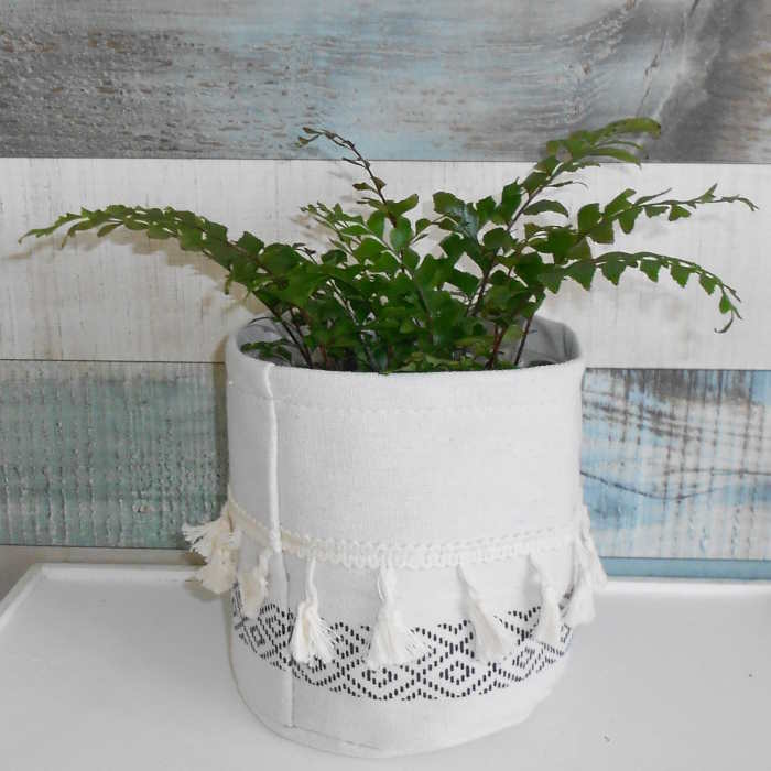 Black and White Tasselled Cotton Plant Pot Cover with a fern plant